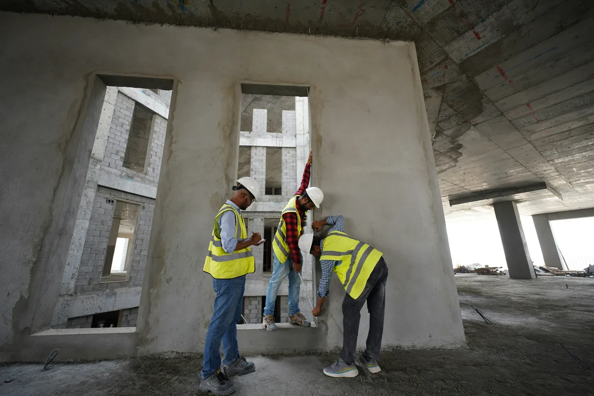 Construction crew reviewing building plans on site, illustrating feet-to-meters construction unit conversion